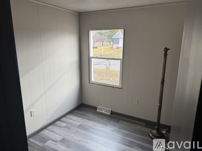 A room with a window and a floor lamp.
