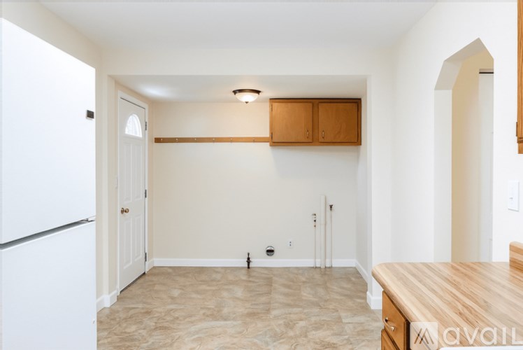 A kitchen with a white fridge and wooden counter top.