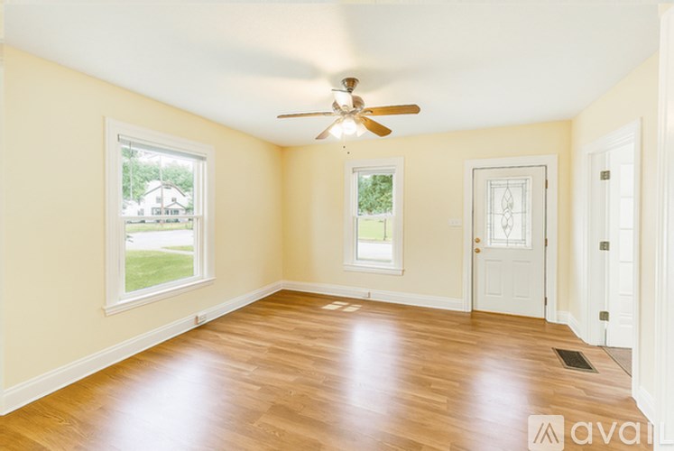 A room with a ceiling fan and wooden flooring.