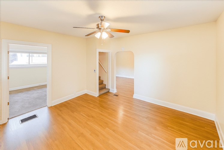 A room with wooden floors and a ceiling fan.