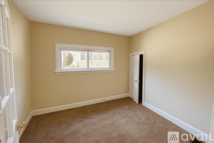 A room with a carpeted floor and a window.