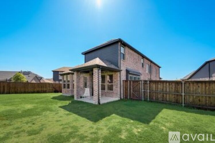 A house with a fence and a sunny sky in the background.