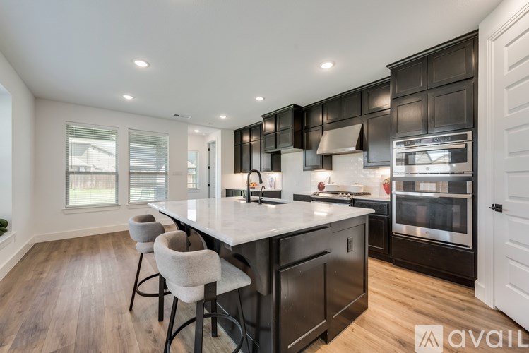 A modern kitchen with a center island and bar stools.