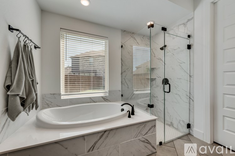 A bathroom with a marble countertop and a large round bathtub.