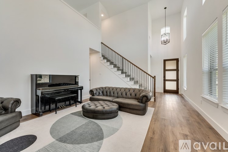 A living room with a piano, a couch, and a rug.