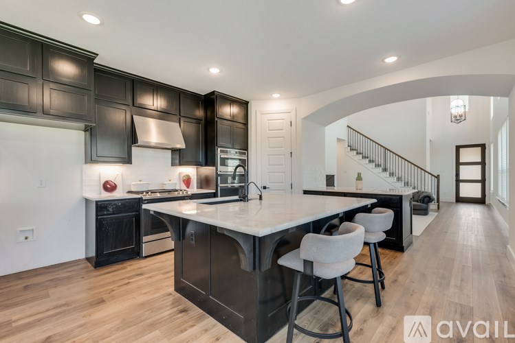 A modern kitchen with a center island and bar stools.