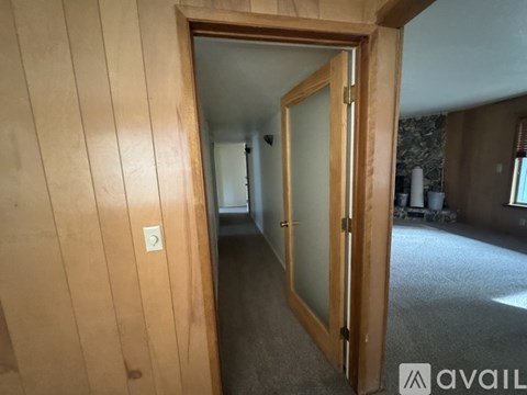 A room with a carpeted floor and a wooden door.
