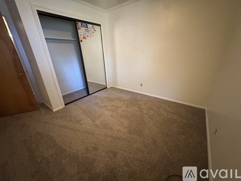 A room with a carpeted floor and a white door with a glass panel.