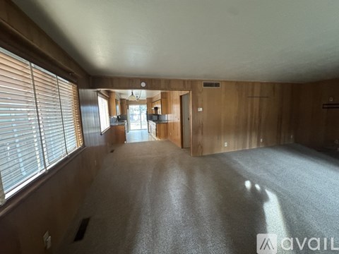 A spacious room with wooden walls and a carpeted floor.