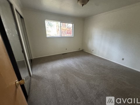 A room with a carpeted floor and a window.