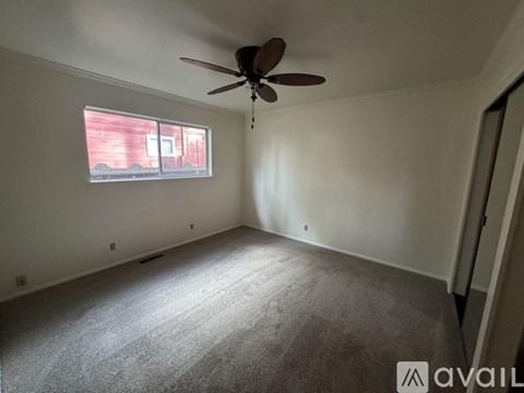 A room with a ceiling fan and a window.