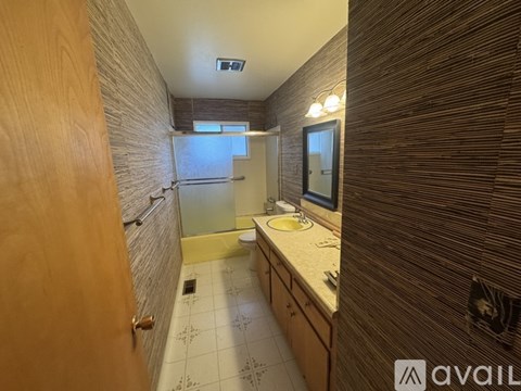 A bathroom with a wooden door and a tiled floor.