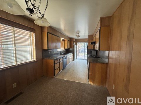 A kitchen with wooden cabinets and a black countertop.