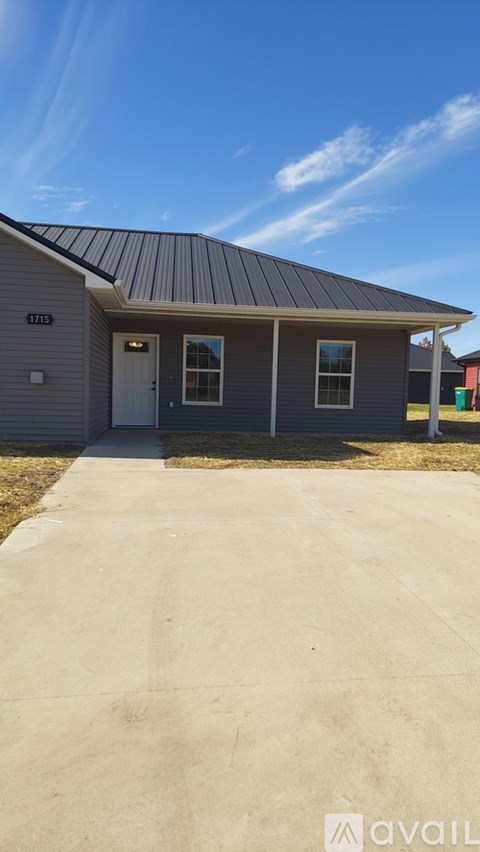 A house with a grey roof and a white door is shown.