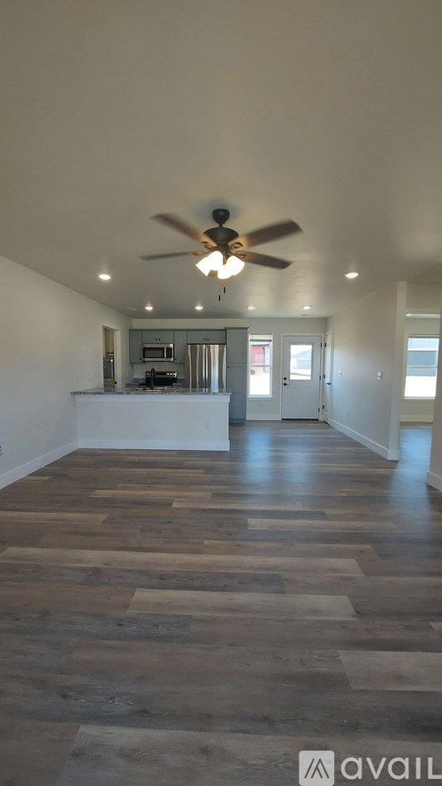 A room with wooden flooring and a ceiling fan.
