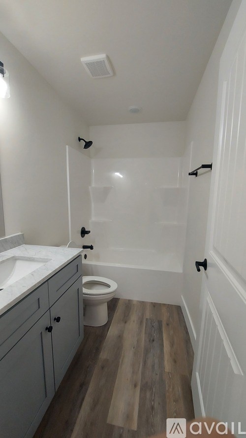 A bathroom with a toilet, sink, and bathtub.