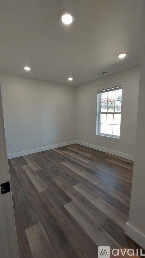 A room with wooden flooring and a window.