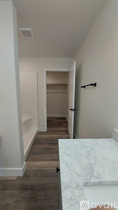 A hallway with a marble counter top and a door at the end.