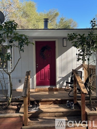 A white house with a red door and a wreath on it.