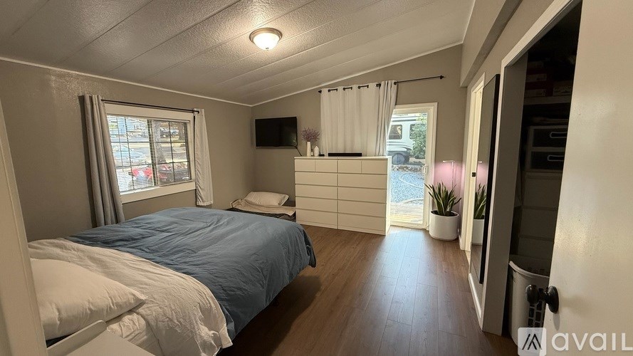 A bedroom with a bed, dresser, and window.