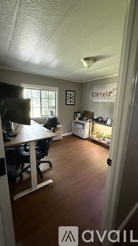 A room with a desk and chairs in it.