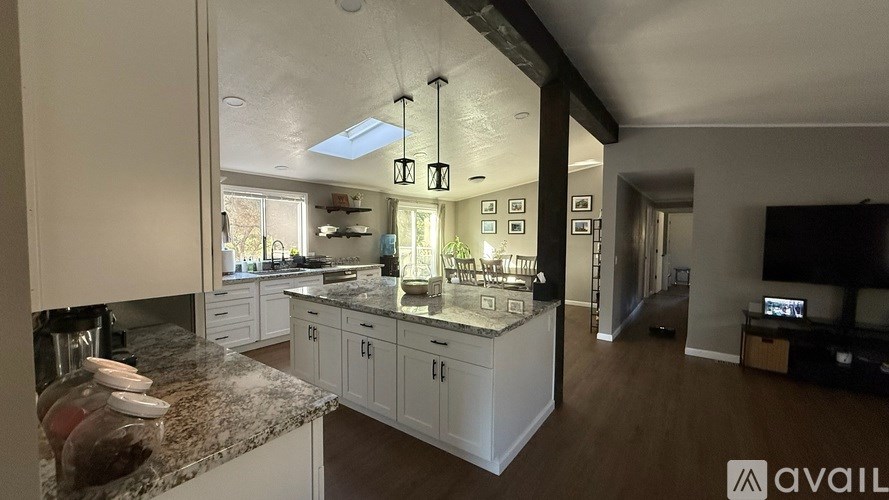 A kitchen with granite countertops and white cabinets is available for rent.