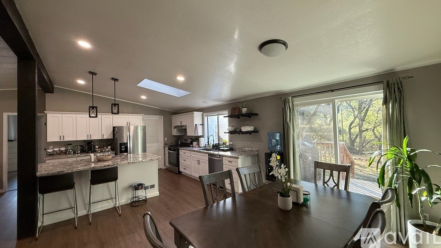 A modern kitchen with a dining table and chairs.