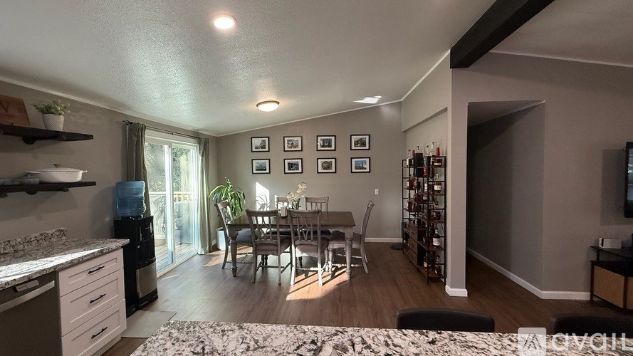 A kitchen with a dining table and chairs in the middle of the room.