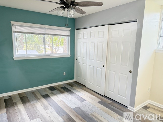 A room with a ceiling fan and two doors.
