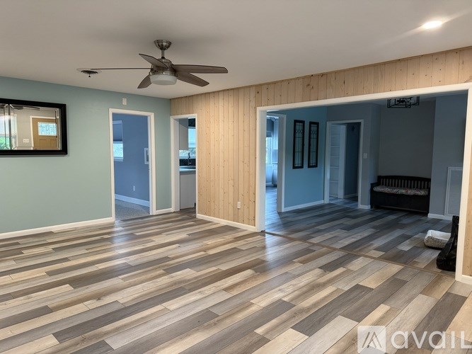 A room with wooden flooring and a ceiling fan.