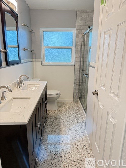 A bathroom with a toilet, sink, and shower.