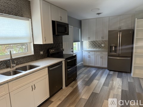 A kitchen with white cabinets and a black stove top oven.