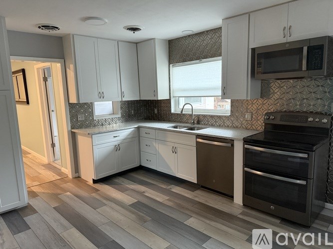 A kitchen with white cabinets and a black oven.