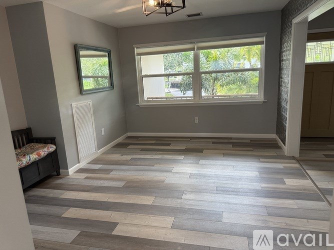 A room with a window and a wooden floor.
