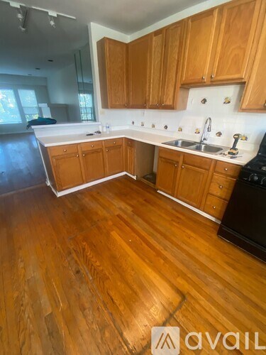 A kitchen with wooden cabinets and a wooden floor.