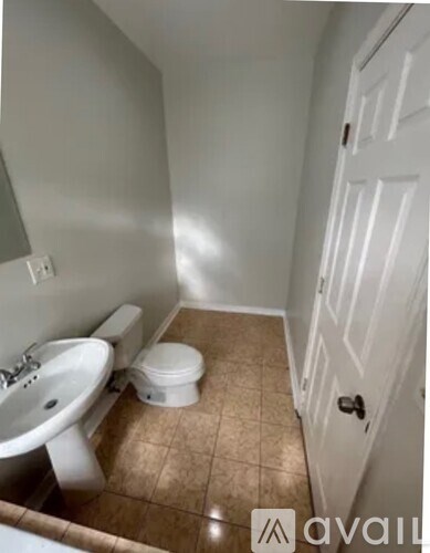 A bathroom with a toilet, sink, and a closed door.
