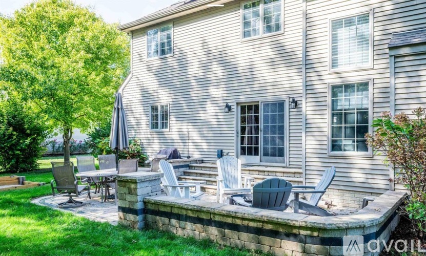 A house with a grey siding and a patio with chairs and a table.