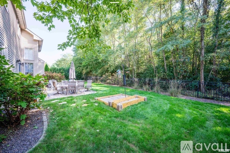 A backyard with a wooden deck and a white umbrella.