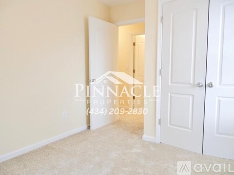 A room with a carpeted floor and two white doors, one of which is open.