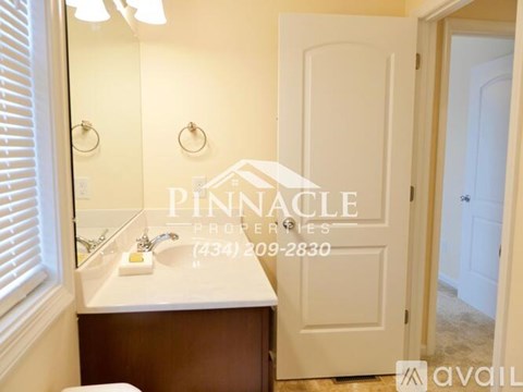 A bathroom with a sink, mirror, and a door.