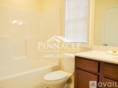 A bathroom with a toilet, sink, and a window with blinds.