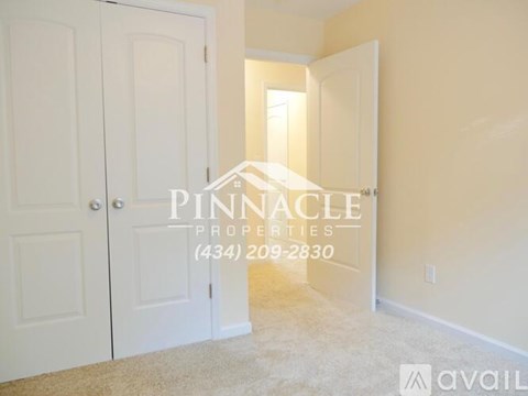 A room with a carpet floor and a door on the left side.