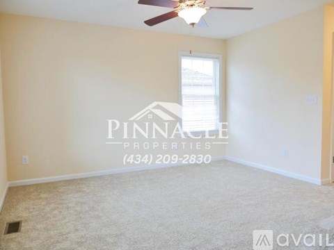 A room with a ceiling fan and a window, with the text "PINNACLE PROPERTIES (434) 209-2830" and "available" on the wall.