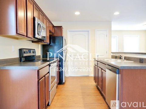 A kitchen with wooden cabinets and a black refrigerator.