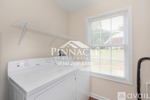 A white dryer is in a laundry room with a window.