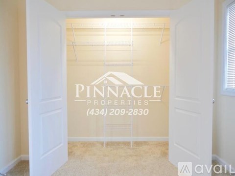 A room with a sign that says "PINNACLE PROPERTIES (434) 209-2830" on the wall.
