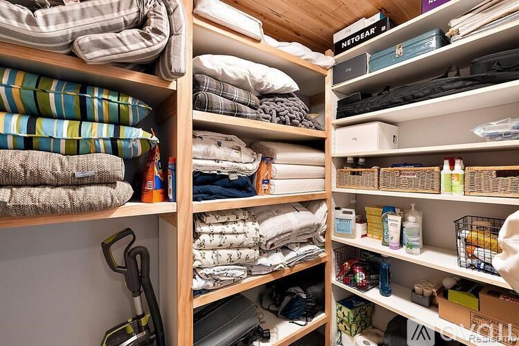 A wooden shelf with towels and other items neatly organized.