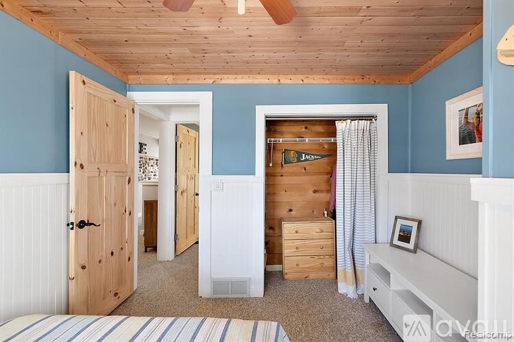 A bedroom with a bed, dresser, and wardrobe.