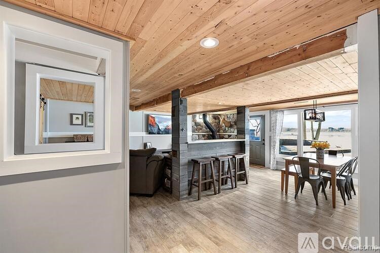 A modern living room with a wooden ceiling and a fireplace.