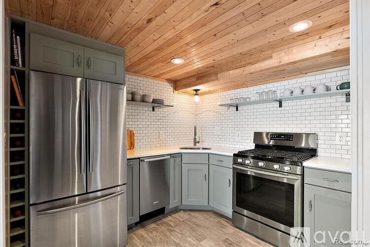 A kitchen with wooden ceiling and stainless steel appliances.